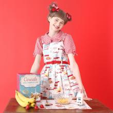 Image of a white dress with a all-over cereal print. There is also text throughout the print that says "Cereals," "Emily's Temple Cute," "Corn Flakes," "Cinnamon Flavor," and "Berry Mix."