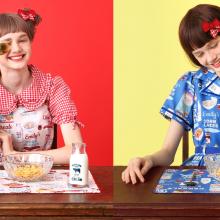 Models wearing both the blue and white cereal print dresses.